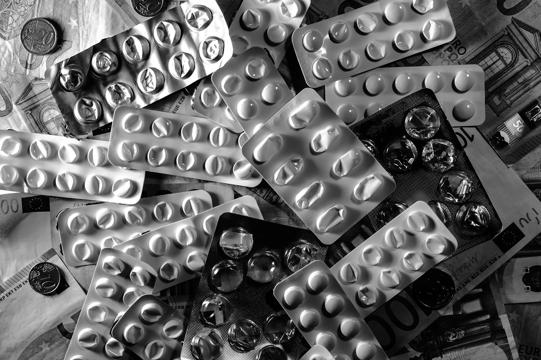 Blistry tabletek leżące na euro banknotach i monetach Blistry tabletek leżące na euro banknotach i monetach