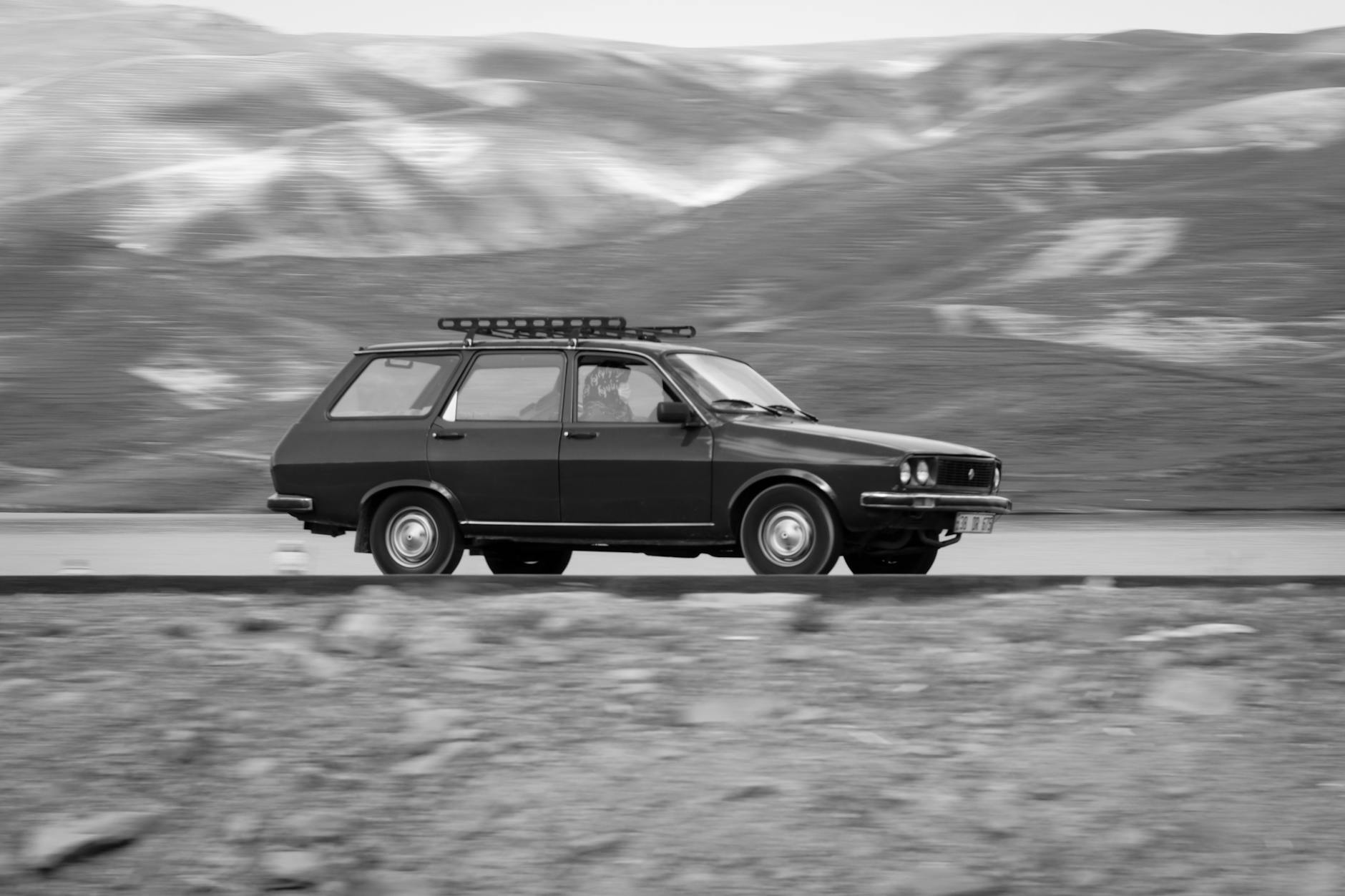 Czarno-biały klasyczny kombi Mercedes jedzie górską szosą